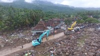 Di Desa Waymuli, alat berat sudah dikerahkan untuk mengangkat puing-puing yang menutupi jalan.