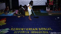 Seorang anak membantu membersihkan tempat pengungsian.