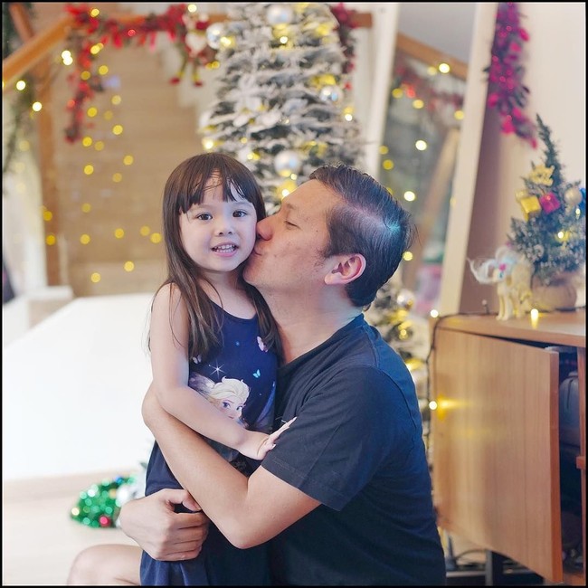 Aktor Gading Marten yang baru saja memenangkan Piala Citra berpose bersama putri semata wayangnya Gempita dengan latar belakang dekorasi Natal di rumahnya. Pohon Natal dengan warna putih dengan hiasan bunga merah menambah cantik rumah Gading. Foto: Dok. Instagram Gading Marten