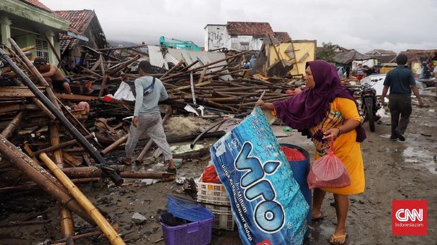 Warga memunguti barang-barang dari reruntuhan sisa terjangan tsunami di desa Sumberjaya, kecamatan Sumur, Pandeglang, Banten, ( 24/12).