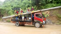Petugas membawa tiang listrik untuk menggantikan tiang yang roboh.
