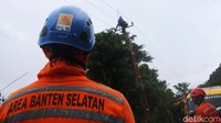 Petugas bahu membahu memperbaiki jaringan listrik yang hancur akibat tsunami.