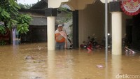 Salah seorang warga menunggu di depan rumah untuk dievakuasi.