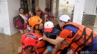 Sejumlah warga nampak menunggu di depan rumah mereka untuk diselamatkan oleh tim SAR gabungan tersebut.