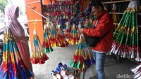 Seorang ibu nampak membeli terompet di kawasan Glodok, Jakarta.
