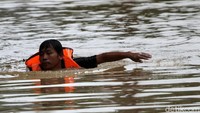 Sejumlah anggota tim SAR gabungan pun berenang untuk menjemput warga yang terjebak di rumah akibat banjir.