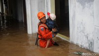 Salah seorang anggota Basarnas menggendong anak kecil untuk dibawa ke pengungsian.