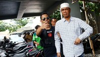 Hercules menggunakan peci saat akan dibawa ke Kejaksaan. Dia hanya melambaikan tangan ke arah wartawan tanpa ada komentar.