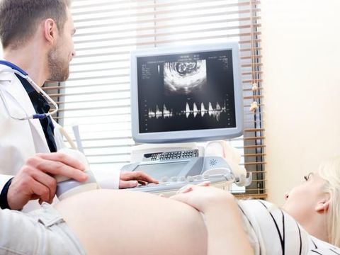 Pregnant woman at the doctor. Ultrasound diagnostic machine. ultrasound transducer woman pregnant doctor prenatal care clinic concept