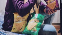 Disela-sela kesibukannya menciptakan musik, Julian hobi ngemil keripik. Ini senyuman manisnya saat mencicipi salah satu keripik tortila kesukaannya. Foto: Instagram @julianjacs