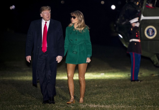 Netizen sempat salah fokus pada penampilan Melania Trump yang terdiri dari coat hijau dan legging coklat yang menyatu dengan warna kulitnya. Istri Presiden AS Donald Trump yang juga mantan artis itu disebut seperti tak memakai celana. (Foto: Pete Marovich - Pool/Getty Images)