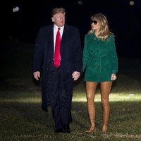 Netizen sempat salah fokus pada penampilan Melania Trump yang terdiri dari coat hijau dan legging coklat yang menyatu dengan warna kulitnya. Istri Presiden AS Donald Trump yang juga mantan artis itu disebut seperti tak memakai celana. (Foto: Pete Marovich - Pool/Getty Images)
