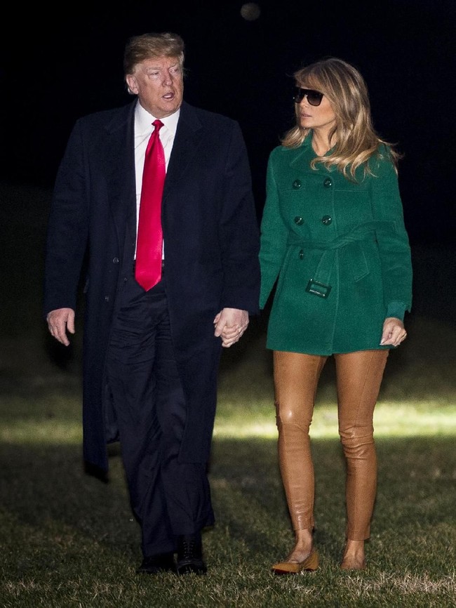 Ada yang menyebut Melania kelupaan memakai celana. Did Melania forget her pants?  Coming off the plane at the base wearing a very short green cost with nothing else on?? tulis @berriesandblood. (Foto: Pete Marovich - Pool/Getty Images)
