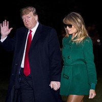 Presiden Amerika Serikat (AS) Donald Trump dan istrinya, Melania, tiba di halaman Gedung Putih, Washington D.C., AS, Kamis (27/12/2018) malam, dari kunjungan singkatnya ke Irak dan Jerman. Melania terlihat mengenakan coat hijau, berikut legging kulit berwarna coklat, flat shoes Louboutin berwarna senada, dan kacamata hitam. (Foto: Pete Marovich - Pool/Getty Images)