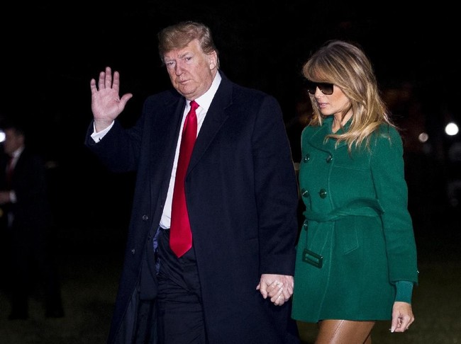 Presiden Amerika Serikat (AS) Donald Trump dan istrinya, Melania, tiba di halaman Gedung Putih, Washington D.C., AS, Kamis (27/12/2018) malam, dari kunjungan singkatnya ke Irak dan Jerman. Melania terlihat mengenakan coat hijau, berikut legging kulit berwarna coklat, flat shoes Louboutin berwarna senada, dan kacamata hitam. (Foto: Pete Marovich - Pool/Getty Images)