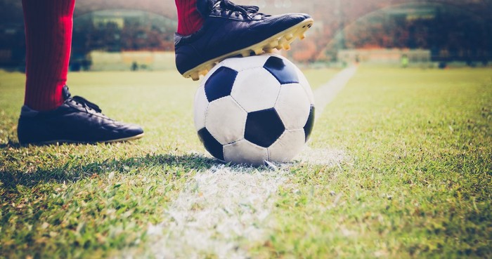 soccer or football player standing with ball on the field for Kick the soccer ball at football stadium