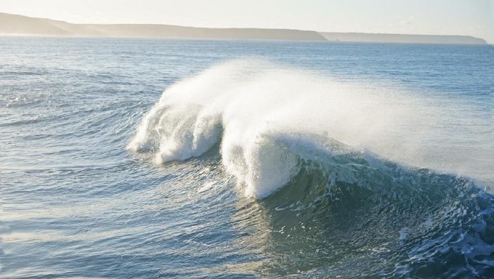 Breaking waves and sea spray in winter at Porthleven, Cornwall, England, UK