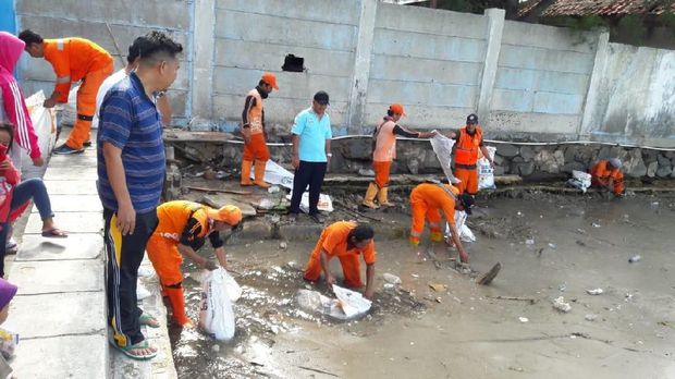  Petugas dan warga bersih-bersih limbah diduga material vulkanik Gunung Anak Krakatau di Kepulauan Seribu, Jumat (28/12/2018)