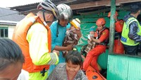 Anggota Tim SAR menggendong bayi dalam proses evakuasi. Pool/SAR Makassar.