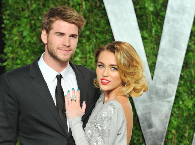 Liam dan Miley muncul bersama di Vanity Fair Oscar party 2012 setelah sempat dikabarkan putus. Miley memanfaatkan momen tersebut untuk mempertegas asmaranya dengan Liam tetap berlanjut lewat pose mesranya. (Foto: Getty Images)