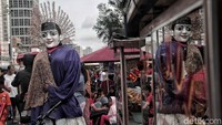 Pengamen ondel-ondel menyusuri Jalan Sudirman, Jakarta Pusat.