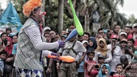 Badut menggelar atraksi untuk menghibur pengunjung car free day. 