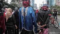 Seorang pengamen berhenti sejenak untuk melepas lelah usai berkeliling di bundaran HI.