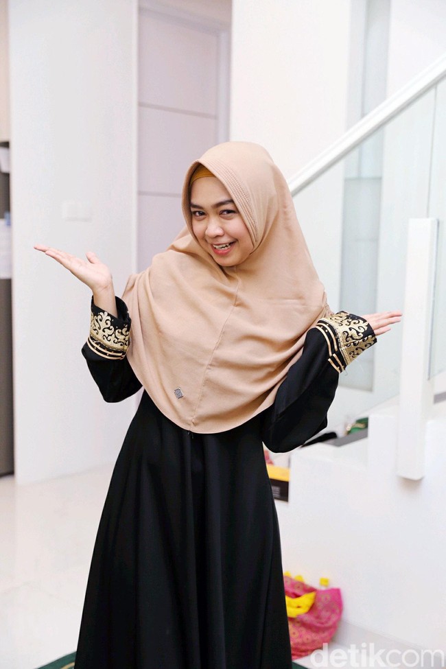 Saat acara syukuran rumahnya, Ria Ricis tampil santun memakai abaya hitam berdetail emas. Ia memadukan busananya dengan hijab instan bernuansa khaki. Foto: Ismail/detikFoto