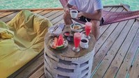 Bersantai dan berlibur di sebuah pulau, Roy terlihat asyik menikmati secangkir kopi dengan irisan buah semangka segar sambil melihat pemandangan laut yang indah. Foto: Instagram @royricardo