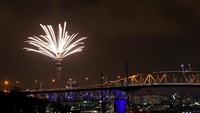Sky Tower di Aukland, Selandia Baru, memancarkan kembang api yang memesona. Hannah Peters/Getty Images.