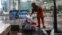 Petugas membersihkan sisa sampah di kawasan Bundaran Hotel Indonesia, Jakarta, Selasa (1/1/2019).
