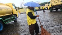Meski hujan rintik-rintik turun, petugas tetap bekerja.