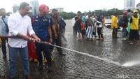 Anies kemudian menemui petugas kebersihan di sekitar Monas. Dia menyalami petugas yang sedang bekerja tersebut.