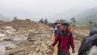 Petugas dan warga meninggalkan area longsor saat di guyur hujan di kampung Cimapag, Desa Sirnaresmi, Kecamatan Cisolok, Kabupaten Sukabumi, Jawa Barat, Selasa (1/1/2019). ANTARA FOTO/M Agung Rajasa.