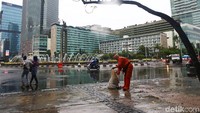 Hujan yang mengguyur Jakarta membuat pekerjaan membersihkan sampah ini semakin berat.