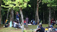 Pengunjung bersantai di taman Monas.