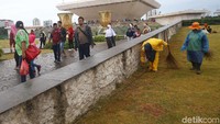 Saat pengunjung asyik berwisata, petugas terus bekerja membersihkan sampah.
