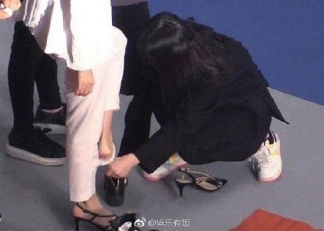 Baru-baru ini beberapa foto yang diduga memperlihatkan asisten Angelababy berlutut di lantai untuk melepas sepatunya jadi viral di media sosial China dan menimbulkan kontroversi. Foto: Dok. Weibo