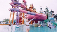 Lihat senyum lebar Milin saat main air di waterpark Thailand ini. Sepertinya seru main perosotan seperti yang ada di belakang Milin. (Instagram/@milinb3rry)