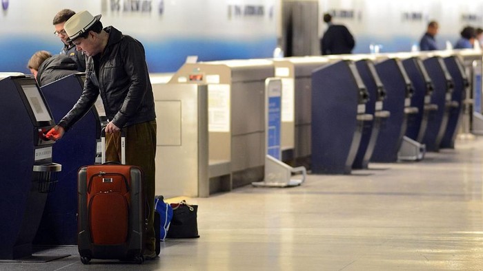 PHILADELPHIA, PA - NOVEMBER 26: Noel Grayson of Chesterbrook, Pennsylvania takes his boarding pass from a kiosk at Philadelphia International Airport November 26, 2014 in Philadelphia, Pennsylvania. Grayson was traveling to Asheville, North Carolina. A winter storm causes travel delays at the airport on the eve of Thanksgiving. (Photo by William Thomas Cain/Getty Images)