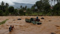 Warga berusaha menarik mobil truk pengangkut batu yang berada di tengah sungai Batang Kuranji akibat terseret banjir di Kecamatan Pauh, Padang, Sumatera Barat. ANTARA FOTO/Muhammad Arif Pribadi.