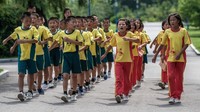 Anak-anak Korea Utara (Korut) sedang melakukan gerak jalan sambil bernyanyi. (Foto: Carl Court/Getty Images)