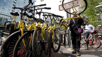 Salah satu petugas yang mengumpulkan sepeda. Foto: Reuters