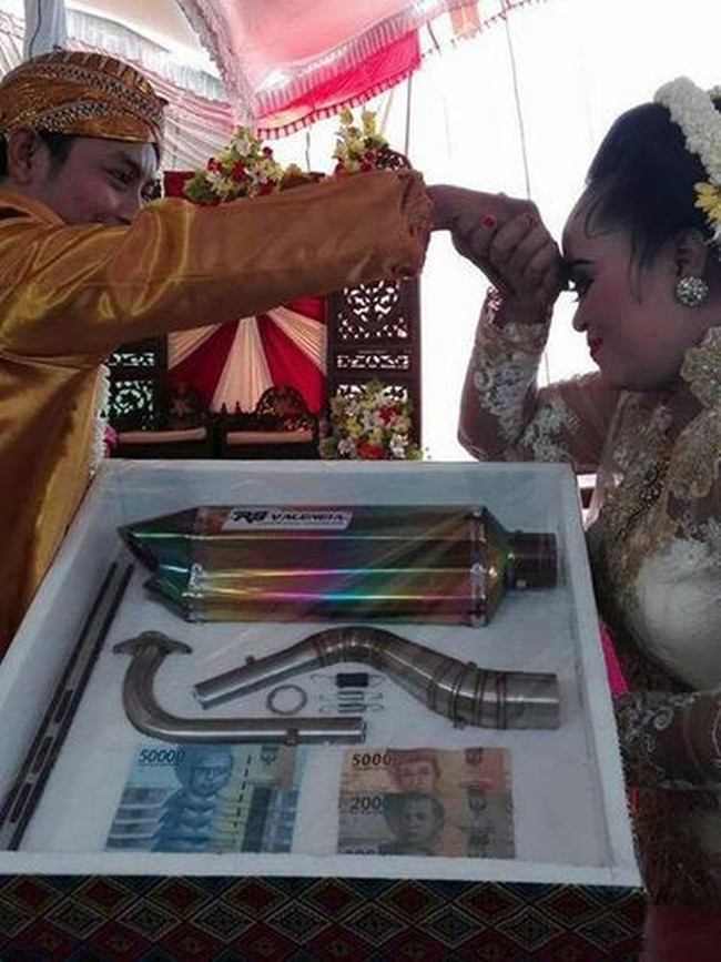 Pasangan di Magetan, Jawa Timur ini memilih benda yang mungkin tak pernah terpikirkan oleh orang lain untuk dijadikan mahar. Alih-alih memilih sejumlah uang atau beberapa gram emas sebagai mahar pernikahan, pasangan ini menjadikan knalpot motor sebagai mahar pernikahannya. Foto: dok. Facebook