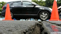 Sebuah mobil melintasi flyover di kawasan Kemayoran yang merenggang.