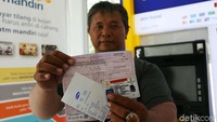 Warga menunjukan bukti pembayaran tilang elektronik melalui ATM Bank Mandiri di Jakarta, Kamis (3/1).