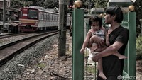 Sejumlah warga menunggu kereta lewat di dalam pagar pembatas kawasan pemukiman pinggir rel kereta api Bukit Duri, Jakarta Selatan, Kamis (3/1).