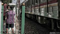 Warga akan menunggu di area tersebut saat kereta melintas.