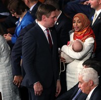 Meski jadi satu-satunya wanita berhijab. Ilhan Omar tampak cair berkomunikasi dengan para anggota. Terlihat ia menggendong bayi putri dari Eric Swalwell. Foto: Getty Images/Win McNamee