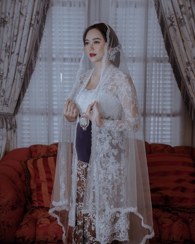 Rancangan kebaya klasik rancangan Era Soekamto yang dikenakan Aura Kasih tampil cantik dengan hiasan bordir dan mutiara di atas kain lace bernuansa bunga. Foto: Dok. Aldi Photography